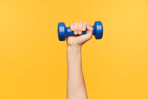 体重用增重剂进行体育锻炼时 女性手被举起的水平镜头 被隔离在黄色背景上减肥和健身概念减肥提高蓝色