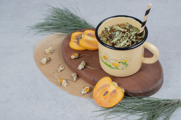 草一杯凉茶 花和柿子片放在木板上高质量的照片杯茶节