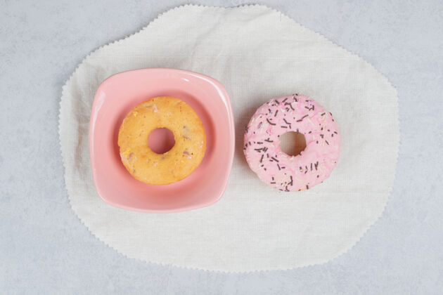 釉大理石桌上有两个带喷头的甜甜圈高质量照片霜甜甜圈甜点