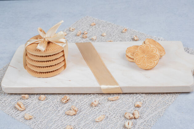 饼干一堆节日饼干和花生放在木板上高质量的照片蝴蝶结面包房糕点