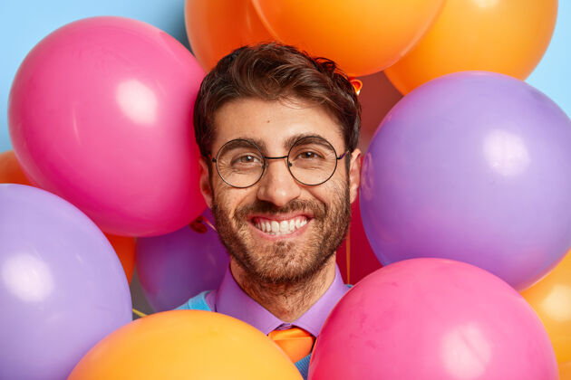 男人微笑的家伙被派对气球包围的特写照片男人帅哥欢呼