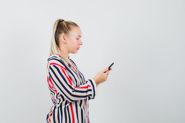 肖像穿着条纹上衣的年轻女子拿着手机发短信 看上去很忙休闲女人女性