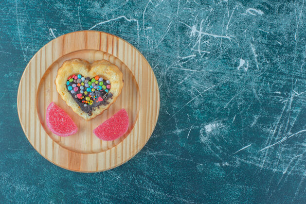 甜点巧克力和糖果填充蛋糕和marmelades在一个蓝色背景的木制盘子高品质的照片馅料烘焙巧克力