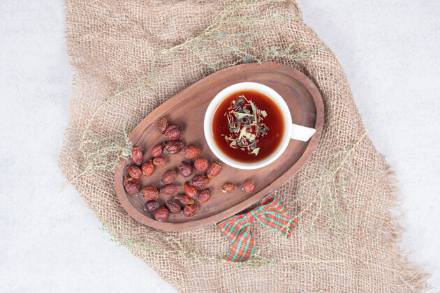 茶一杯茶和干蔓越莓放在粗麻布上高质量的照片野生浆果草药浆果