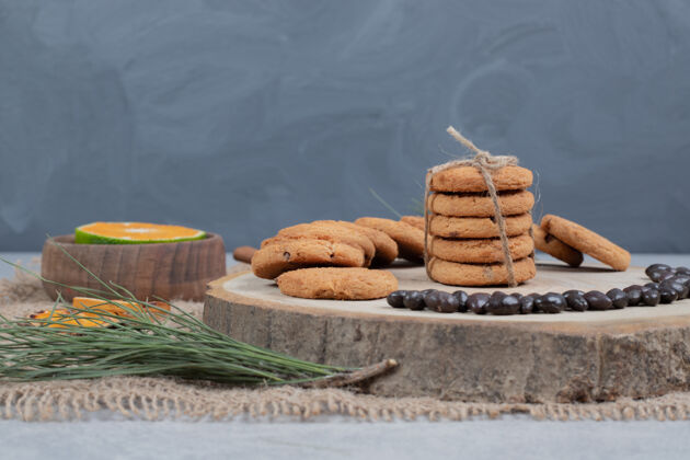 饼干巧克力曲奇饼干放在木板上 上面有谷物和橘子片高质量的照片粗麻布饼干谷物