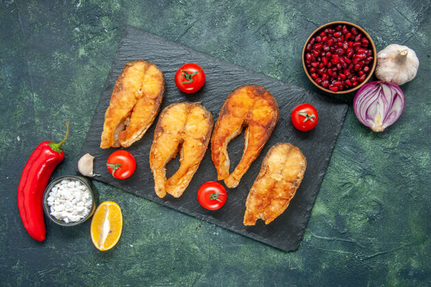 烹饪红色西红柿 大蒜 柠檬和红辣椒的美味炸鱼俯瞰图美味鱼肉