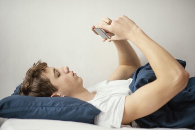 床孩子在床上拿着手机躺在床上小玩意技术