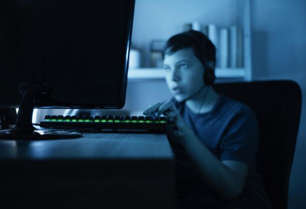 设备玩电脑的小男孩电脑键盘耳机