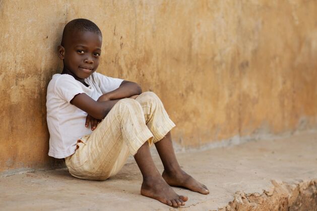 种族坐在户外的全镜头小子第三世界生活方式男孩