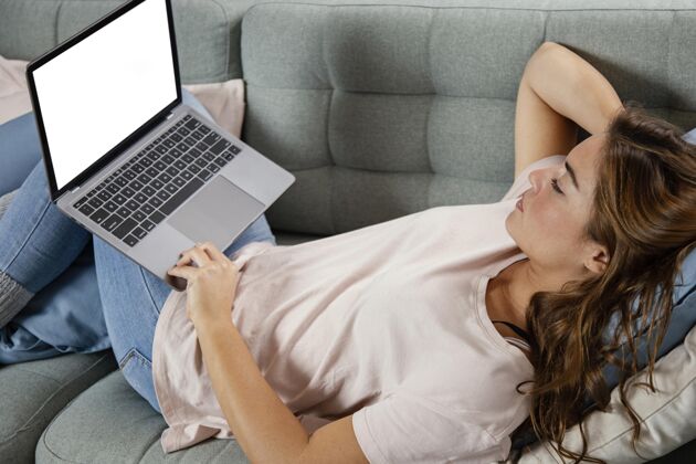 流坐在沙发上拿着笔记本电脑的女人室内技术小玩意