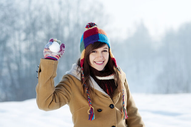 寒冷扔雪球的年轻女子多种颜色霜冻帽子