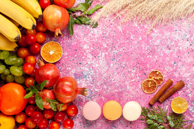 水果顶视图新鲜水果组成与法国马卡龙在浅粉红色的表面法国根类蔬菜维生素