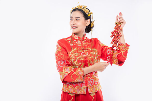 中国民族穿旗袍套装的女士在春节向客户展示烟花爆竹出售欢呼文化中国文化