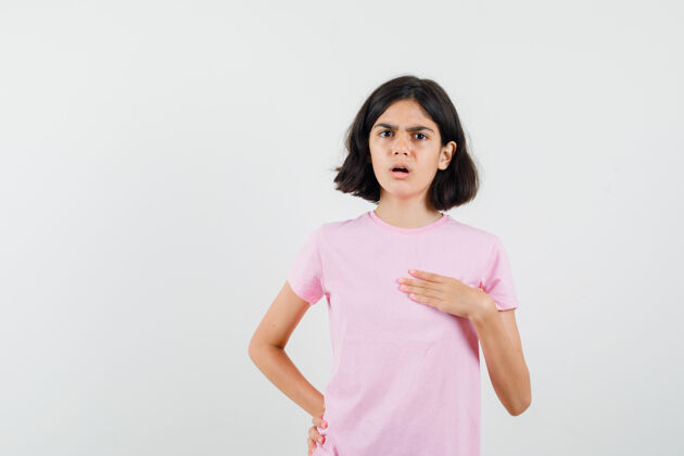 青少年小女孩指着自己在粉红色的t恤衫 看着困惑前视图可爱拼图女孩
