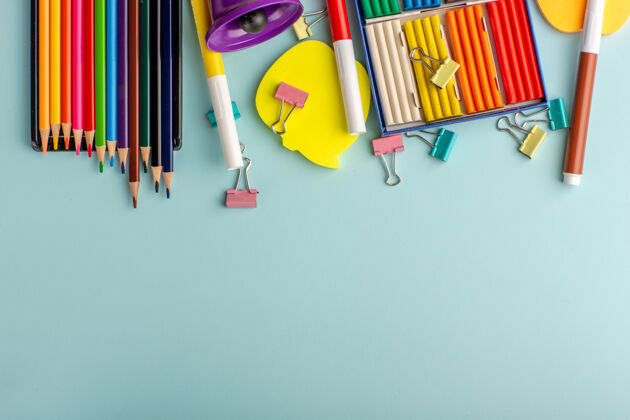 蜡笔顶视图彩色橡皮泥与彩色铅笔上的蓝色书桌彩色学校的孩子们的书绘画教育书桌