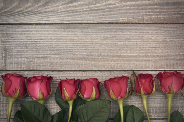 木板一排切好的红玫瑰桌子安排空