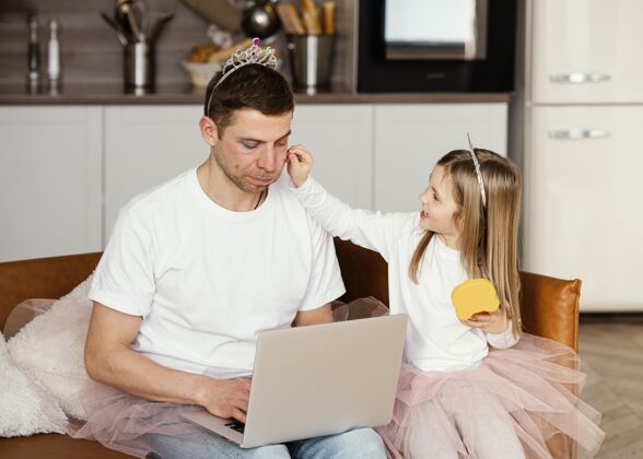 女儿当爸爸在笔记本电脑上工作时 女儿正在和他玩男人孩子父亲节