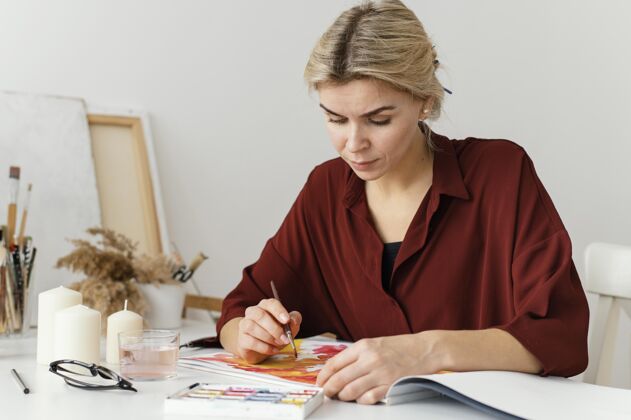 爱好在纸上用水彩画的女人放松女性艺术家