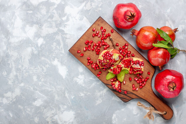 盘子白色书桌上的红色石榴新鲜多汁的水果树餐植物