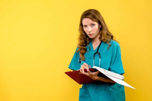 专业正面图女医生在黄色空间写笔记成人人护士