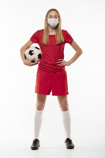 年轻戴着面具拿着球的女足球运动员足球足球运动员持球