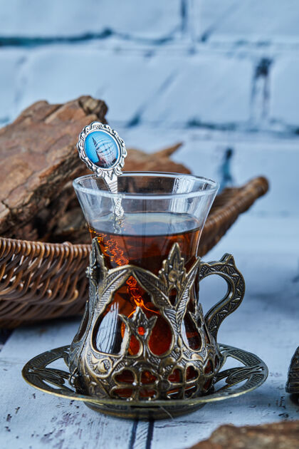 阿塞拜疆红茶放在传统的玻璃杯子里 饼干放在蓝色的木桌上茶勺子传统的