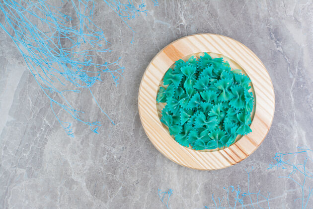 厨房蓝色的自制意大利面放在一个圆木盘里健康菜肴膳食