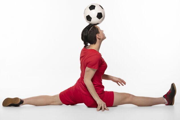 运动用足球表演杂技的女人年轻足球制服女