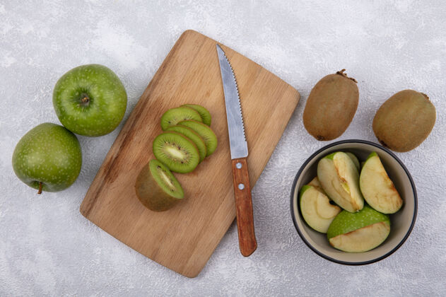 苹果顶视图猕猴桃切片与切肉板上的绿色苹果片在白色背景碗食物顶部绿色
