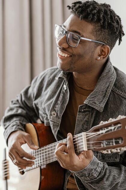 技能笑脸男音乐家在家弹吉他侧视图熟练程度娱乐创意