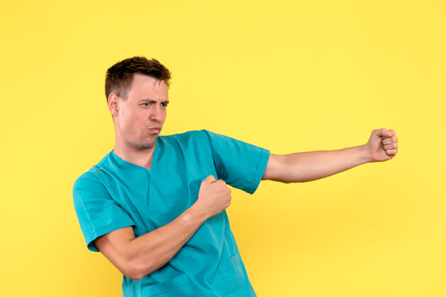 运动装前视图的男医生试图在黄色的墙上跳舞健身快乐尝试