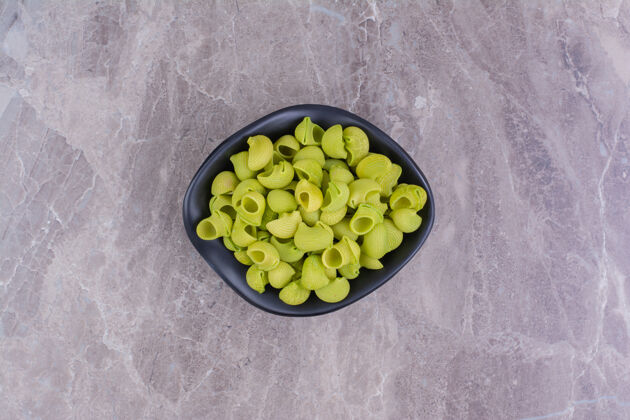 自制绿色的生面食放在大理石上的陶瓷碗里生物餐厅菜肴