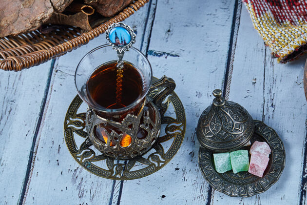 阿塞拜疆红茶放在传统的玻璃杯子里 蓝色的木桌上放着糖果传统的杯子碗