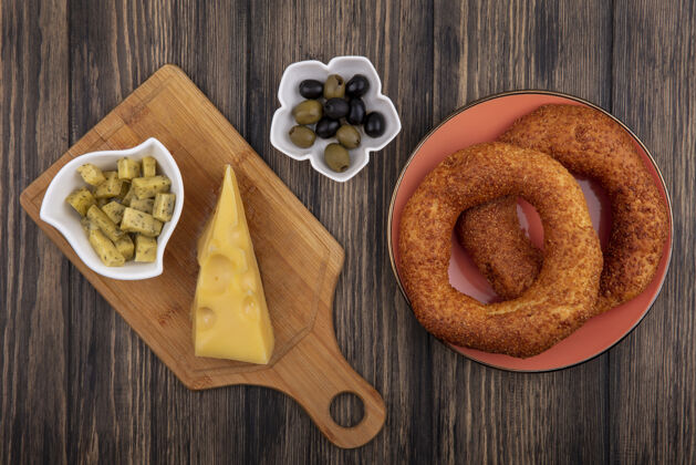 奶酪美味的土耳其芝麻百吉饼在盘子上的俯视图 橄榄放在碗上 奶酪放在木制背景的木制厨房板上盘子土耳其食物