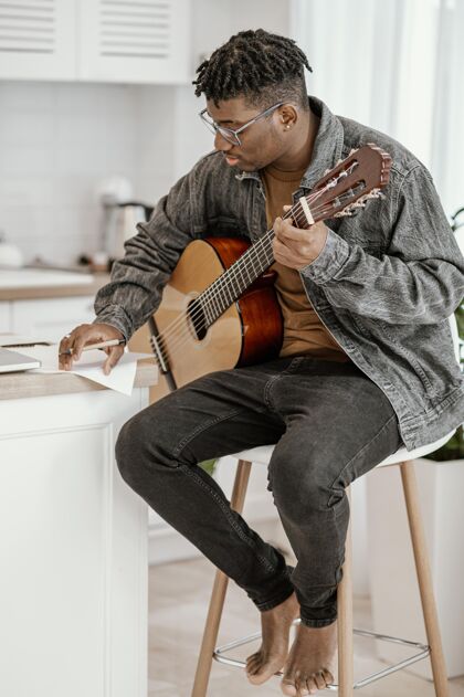 音乐家侧视图男音乐家在家里弹吉他技能垂直男人