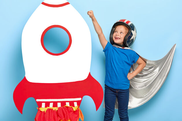 T恤照片中的小女孩儿做着飞翔的手势 假装拥有超能力 准备飞翔拯救世界 穿着斗篷姿势探索飞行