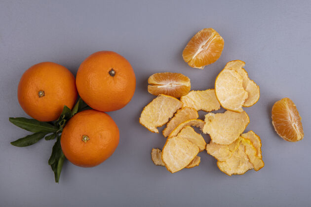 五颜六色在灰色背景上用果皮顶视图橘子橘子顶部灰色