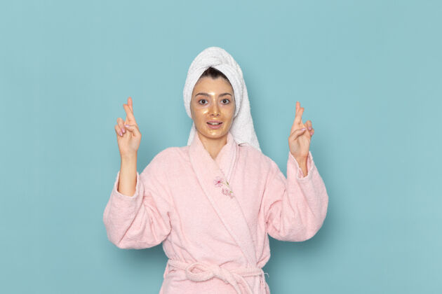 浴袍正面图身着粉色浴袍的年轻女性在蓝色墙壁上沐浴后 享受美丽的水浴霜自理淋浴浴室男性前面自理