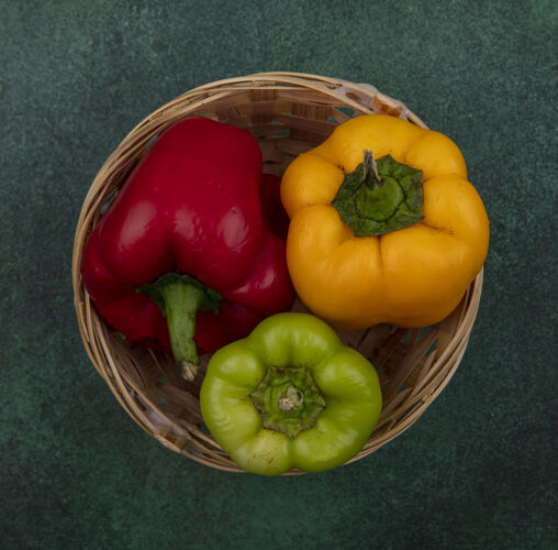 胡椒顶视图甜椒在一个绿色的背景篮子篮子新鲜铃铛胡椒