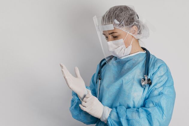 医院戴着外科手套的年轻医生大流行工作预防