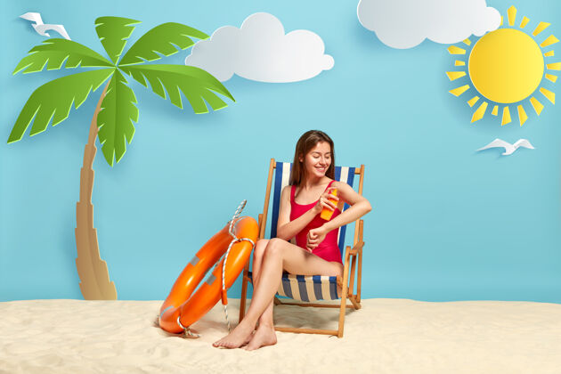 减肥微笑的美女在沙滩椅前摆姿势日光浴乳液皮肤护理
