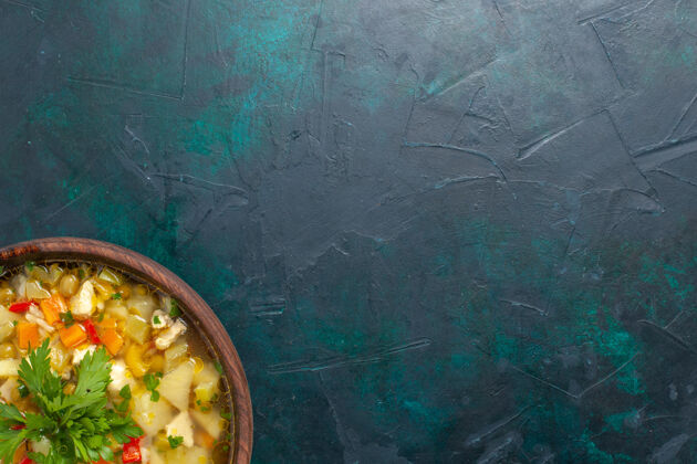 灯光俯瞰美味的蔬菜汤与切片蔬菜和蔬菜上的深蓝色背景汤蔬菜食物餐热食物晚餐酱容器生的背景
