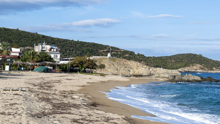 度假村爱琴海海岸左侧有建筑物 岩石 灌木丛和树木 希腊萨尔蒂的碧波荡漾海岸观点沙