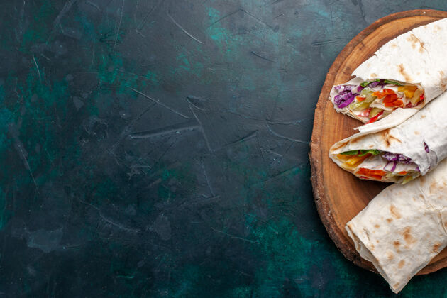 上衣俯视图肉三明治一个三明治 用烤肉做成 在深蓝色的桌子上烤 三明治 汉堡包 食物 午餐 肉 照片家具午餐自制的
