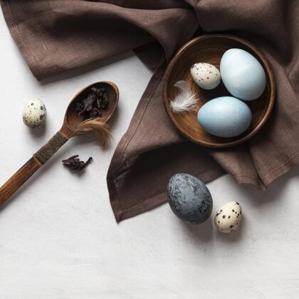 平铺复活节彩蛋的顶视图 用木勺和羽毛放在盘子里星期天帕夏复活星期天