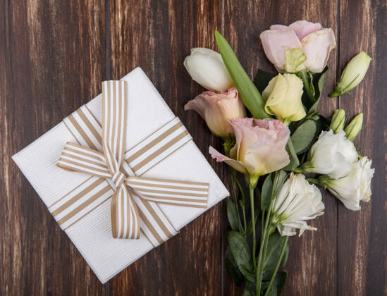 郁金香顶视图美丽的花朵 如郁金香和玫瑰与礼品盒隔离在一个木制的背景像花礼物