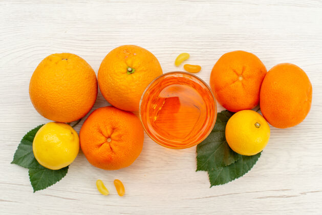 生的顶视新鲜橙汁与橘子和柑橘对白色表面柑橘异国情调的热带果汁多汁的新鲜异国情调