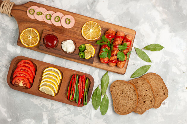面包顶视图不同的食物组成西红柿柠檬香肠甜椒配面包面包浅白桌上餐蔬菜食物午餐照片面包生的肉