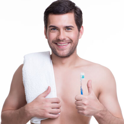 毛巾一个带着牙刷的微笑的年轻人的肖像-孤立在白色上洗脸卫生帅哥