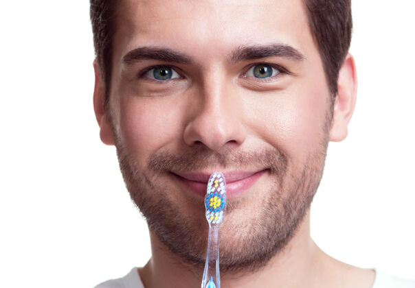 帅哥？？？一个戴着牙刷的快乐的年轻人的失传肖像-孤立在白色上牙刷微笑站立